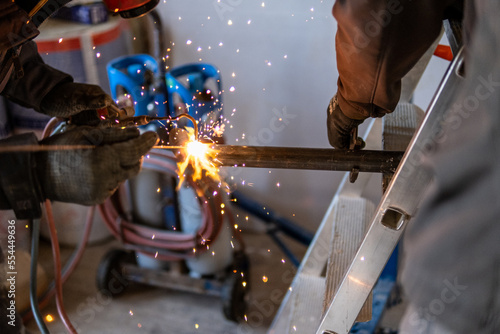 Man welding a gas pipe with flames and sparks