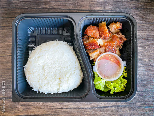 Fried crispy pork with jasmine rice in the food containner photo