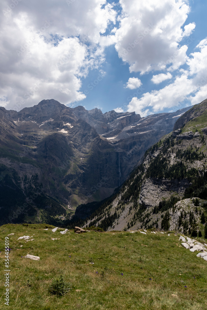 Famous Gavarnie Falls in French Pyrenees, the highest waterfall in mainland France. View from Plateau de Bellevue, with green meadows in foreground.