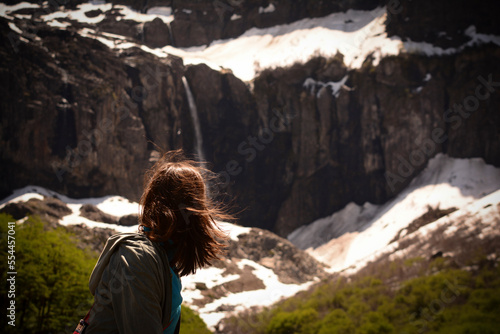 young woman from behind looking at a waterfall. a waterfall near cerro tronador in argentinian patagonia