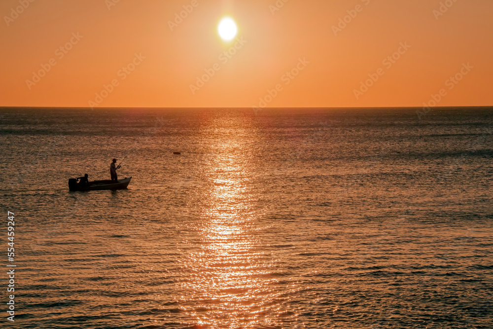 Deux pêcheur sur une barque au crépuscule en Guadeloupe
