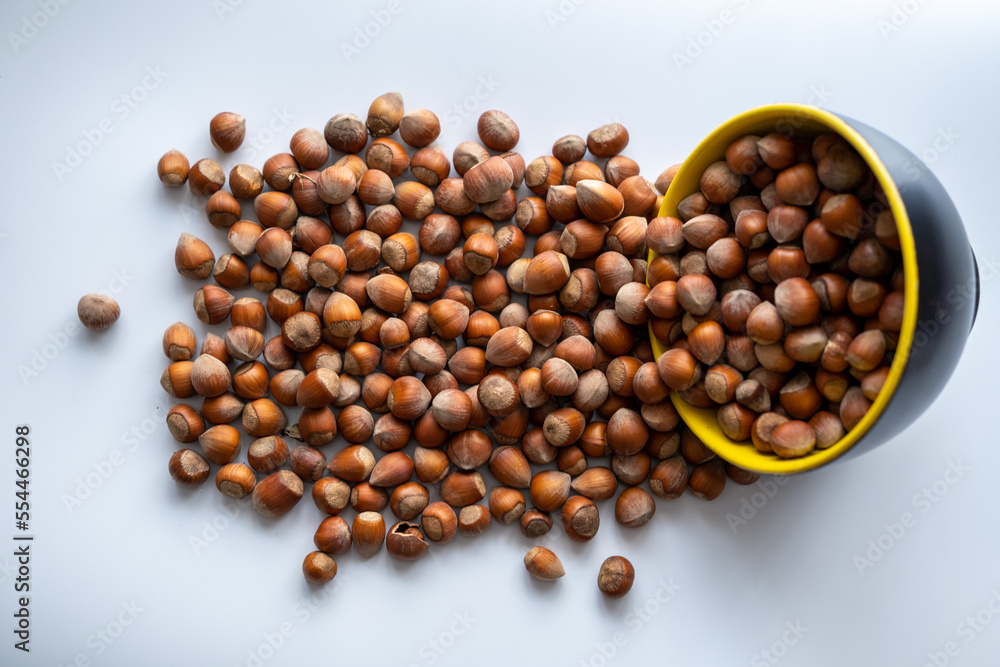 Nuts, hazelnuts spilled, Hazelnuts spilled from bowl on floor, top view Nuts, hazelnuts spilled, Hazelnuts spilled from bowl on floor, top view