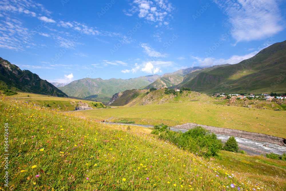 A beautiful mountain landscape with a small meandering river and a blue sky. Mountainous Georgia.