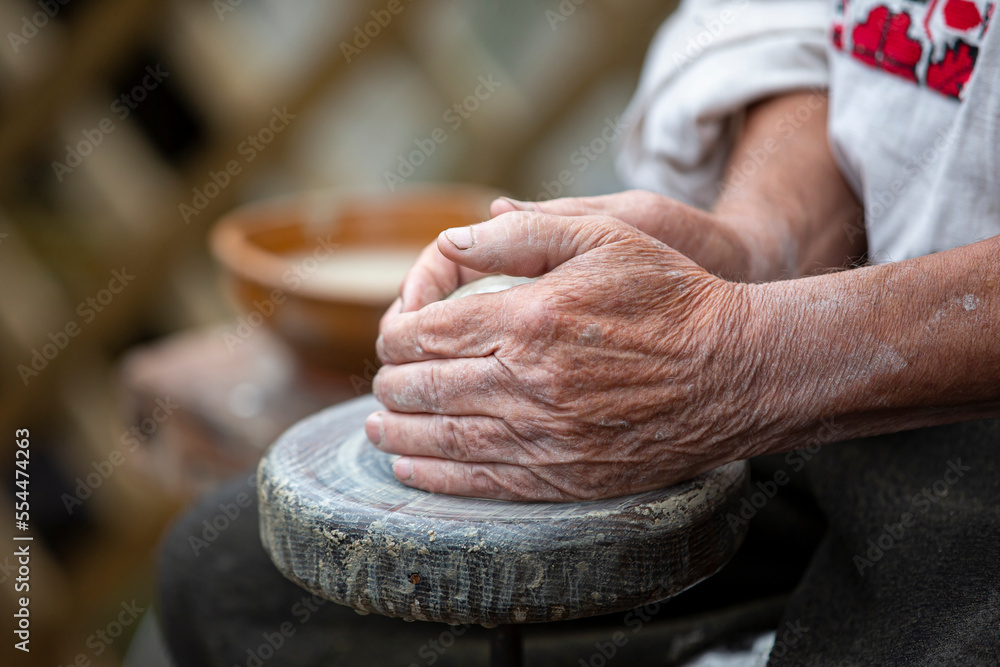 The old hands of the master make products from clay. Work on the potter's wheel.