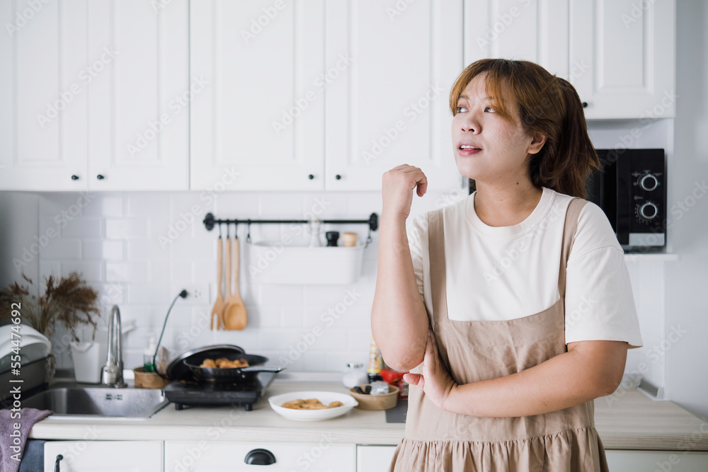 Relaxing and proud of herself concept, happy Asian woman looking far away, in her own home kitchen. Relaxing and proud of herself concept, happy Asian woman looking far away, in her own home kitchen.