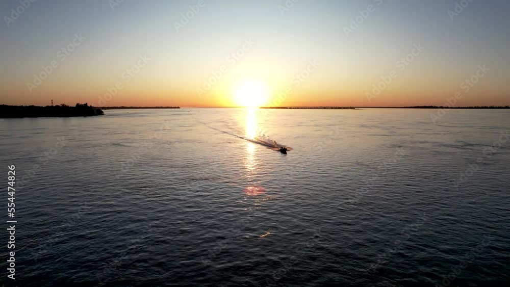 Beautiful sunset over the river, with boats fishing in the background. Beautiful sunset over the river, with boats fishing in the background.