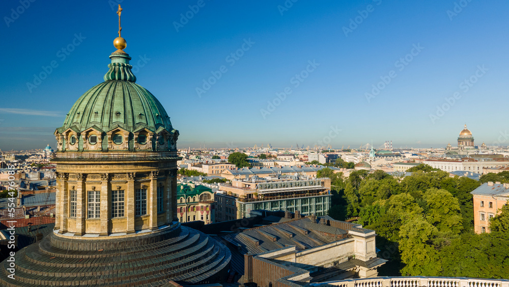 Aerial front, up view of the dome and colonnade of the Kazan Cathedral in the historical city of St. Petersburg at sunny summer dawn, gold