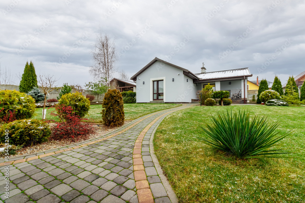 Guest house with green lawn and plants, with a small amount of snow falling Guest house with green lawn and plants, with a small amount of snow falling