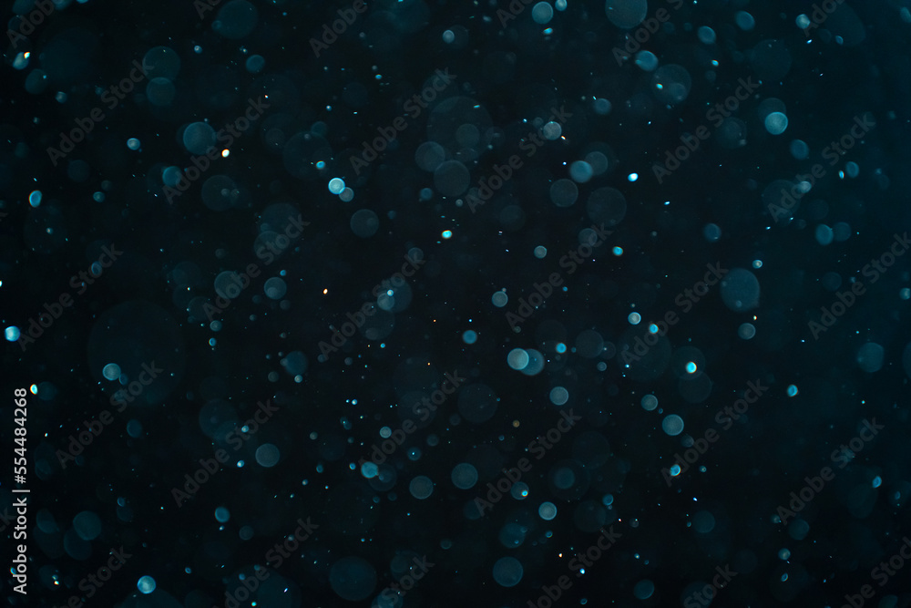 Abstract real dust particles on black background. Glittering sparkling bokeh overlay design with copy space for text. High quality photo