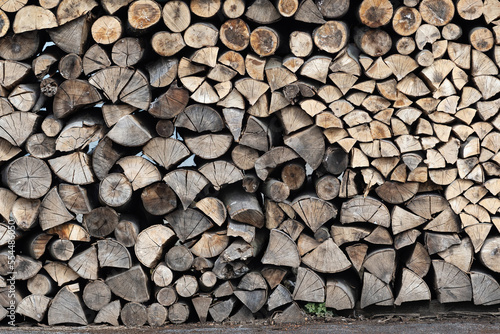 Dry firewood stacked in a pile  chopped wood for winter heating fuel of the fireplace. Natural wood background.