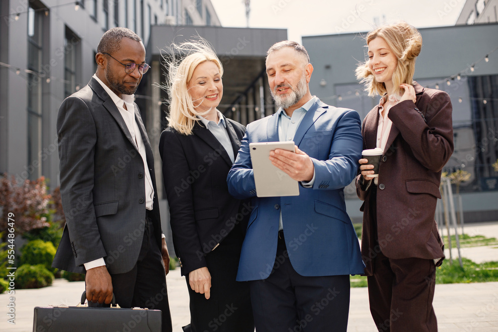 Business people standing and talk to each other in front of modern office Business people standing and talk to each other in front of modern office