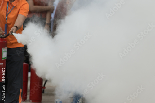 Showing how to use a fire extinguisher on a training fire for employees industry.Fire fighter concept.