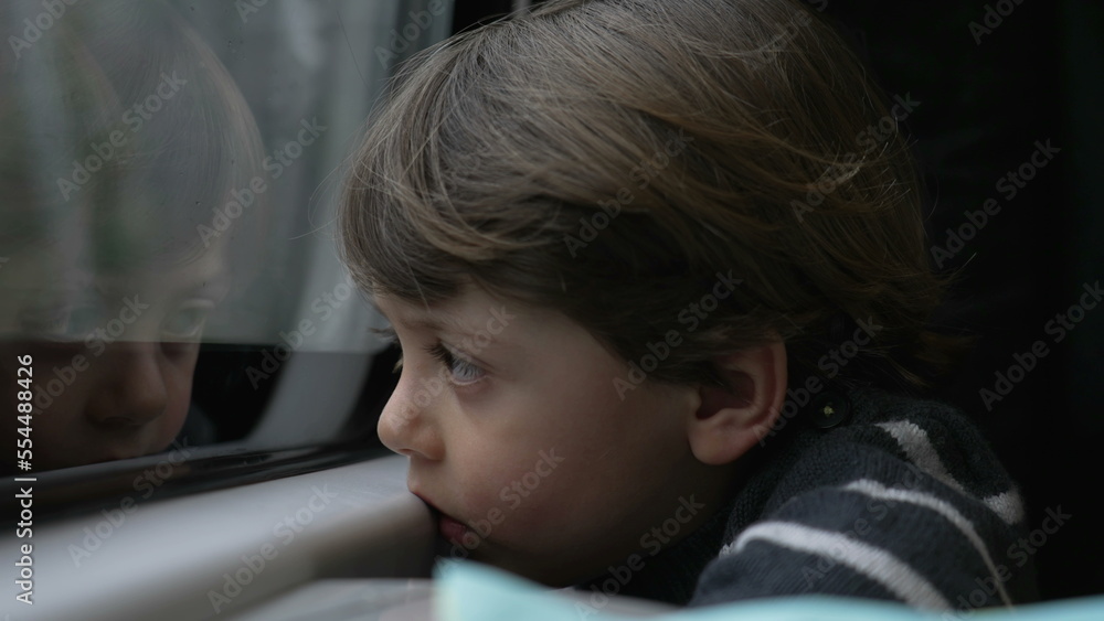 One sleepy little boy almost falling asleep while traveling on train in motion. Portrait of passenger child by window looking at landscape One sleepy little boy almost falling asleep while traveling on train in motion. Portrait of passenger child by window looking at landscape