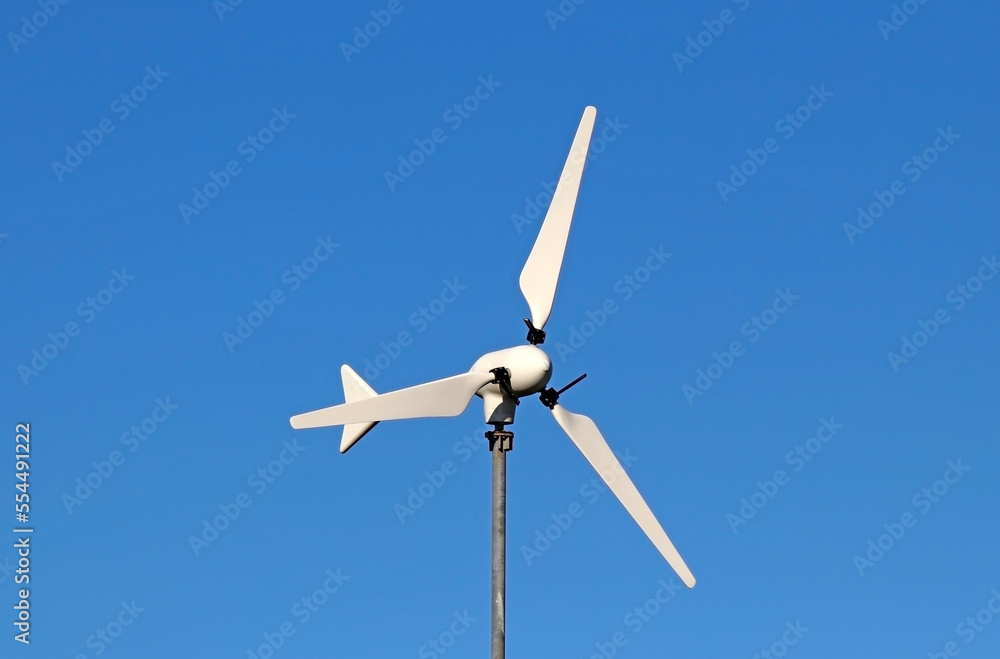 A small-scale wind turbine. Concept of sustainability and green energy A small-scale wind turbine. Concept of sustainability and green energy
