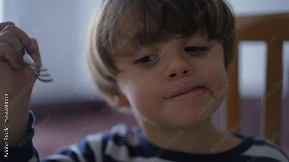 Child eating spaghetti by himself. One small boy eats noodles with fork Child eating spaghetti by himself. One small boy eats noodles with fork