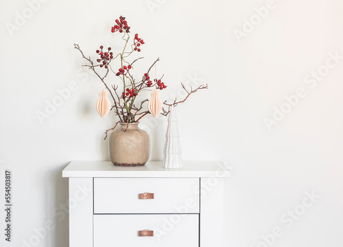 Christmas composition with branches and ceramic Christmas tree on a wooden white table