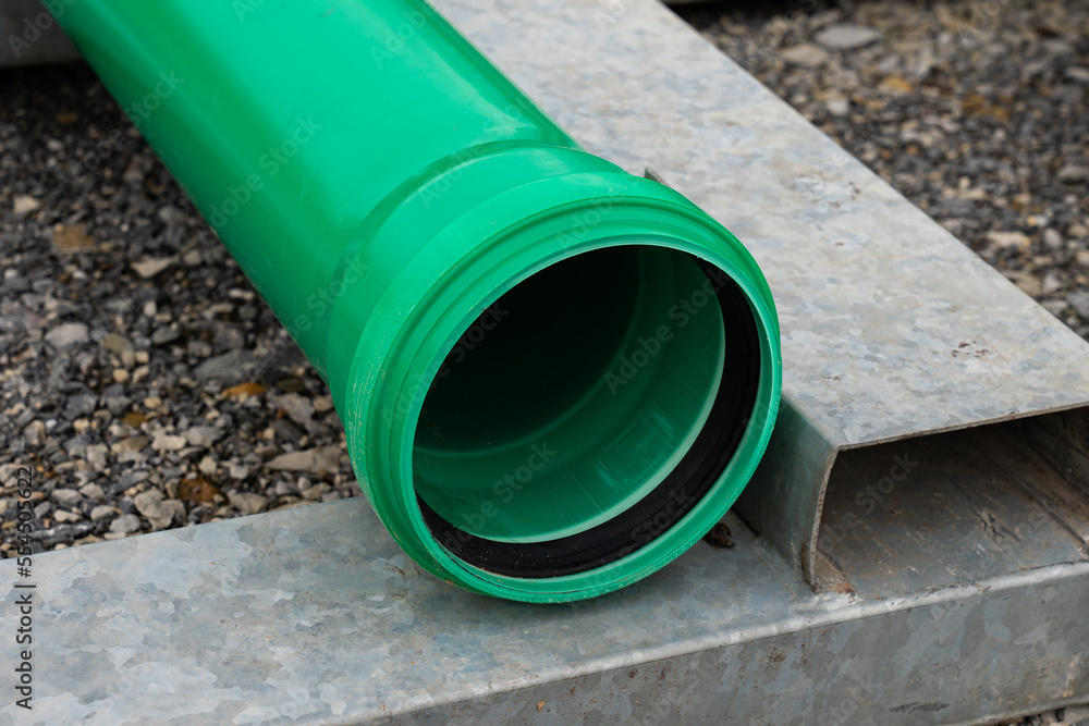 Part of green plastic pipe with a connecting flange at the end. Close-up. Part of green plastic pipe with a connecting flange at the end. Close-up.