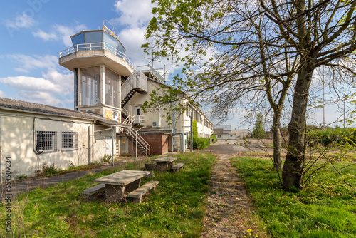 Fotografie An old tower of an abandoned US military airbase against a blue cloudy sky on a