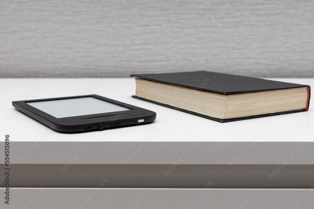 e-book lies on the table near paper books. e-book lies on the table near paper books.