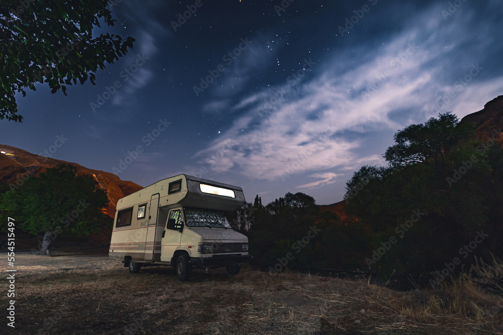 motorhome among the trees at night under stars