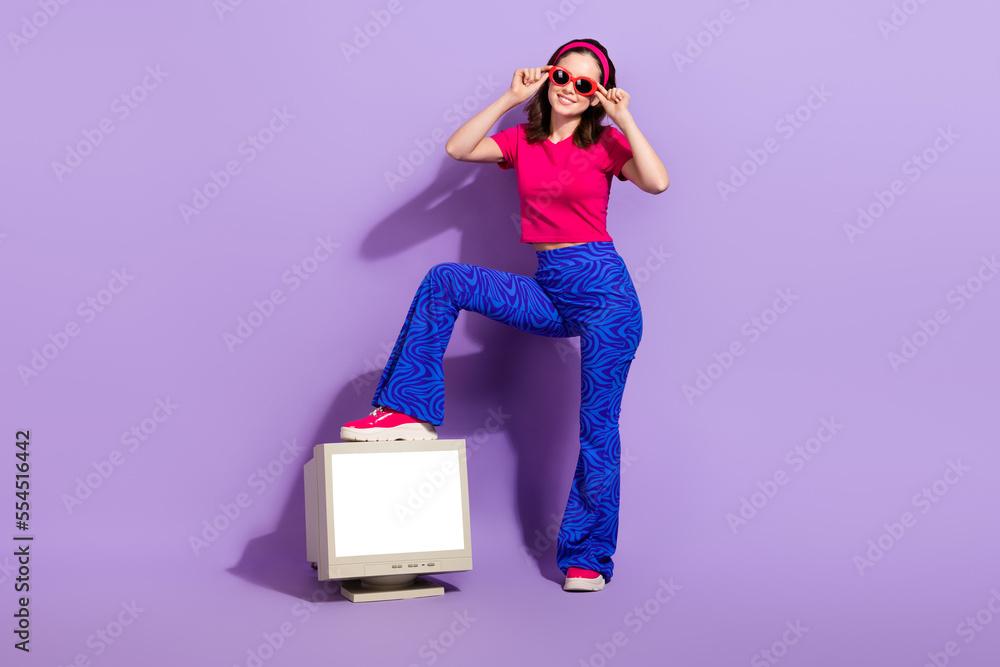 Obraz premium Photo of confident successful optimistic lady wear stylish clothes stand old box monitor empty space isolated on purple color background