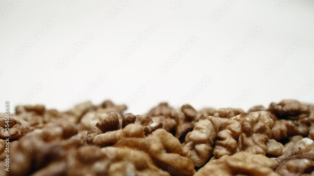Close-up walnuts pile, lot of whole nuts on white background dolly slide shot. Place for title, text or logo, template for adding text. Healthy food, diet, dieting Close-up walnuts pile, lot of whole nuts on white background dolly slide shot. Place for title, text or logo, template for adding text. Healthy food, diet, dieting