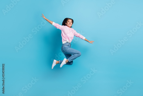 Wallpaper Mural Full length photo of sweet cute girl dressed pink pullover jumping high arms sides isolated blue color background Torontodigital.ca