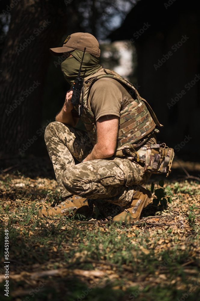 A military soldier in a special uniform with a tactical backpack in the forest
