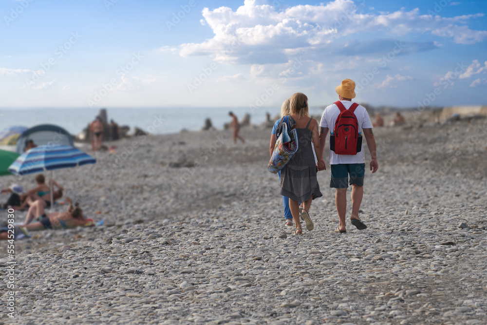 Beach holidays on an unequipped (wild) beach. Tourists are located under umbrellas from the sun near the coastline or choose a convenient place to relax. Beach holidays on an unequipped (wild) beach. Tourists are located under umbrellas from the sun near the coastline or choose a convenient place to relax.