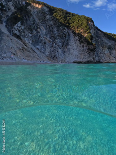 Underwater split sea level photo of famous paradise pebble beach of Myrtos one of the best in island of Kefalonia, Ionian, Greece