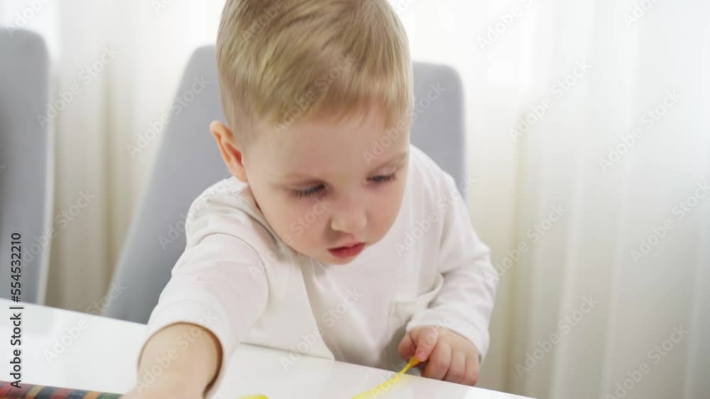 A boy unwinds a yellow gift wrapping ribbon. Preparation for the holiday. A boy unwinds a yellow gift wrapping ribbon. Preparation for the holiday.