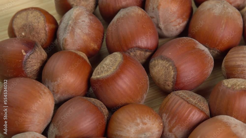 Hazelnuts in shells rotate on wooden background close up. Whole and shelled organic hazelnuts on a wooden table. Nut in shell video concept Hazelnuts in shells rotate on wooden background close up. Whole and shelled organic hazelnuts on a wooden table. Nut in shell video concept