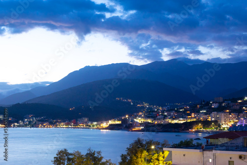 Twilight landscape of a resort Himare town located in a bay at the foot of the mountains. Ionian sea. Albania.