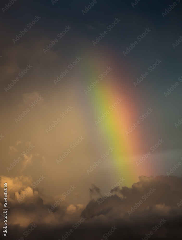 Vertical rainbow over cumulus clouds over the Gulf of Mexico within sunset, Longboat Key, Sarasota, Florida