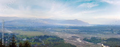 Summer misty morning mountain village panorama (countryside landscape).