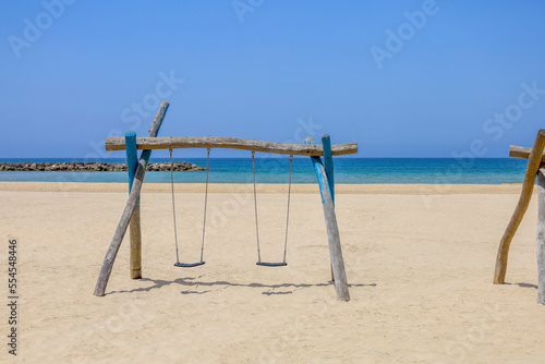 View of children's swings on sea beach