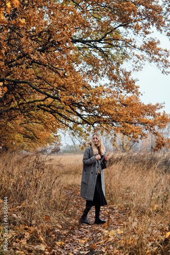 Girl walks in the autumn park. Beautiful autumn landscape, fall foliage. Outdoor activities. Autumn walk in nature. Enjoy the weather and fresh air. Travel and exploration