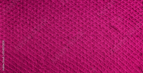 Knitted background in crimson color. Knitted texture of woolen fabric.
