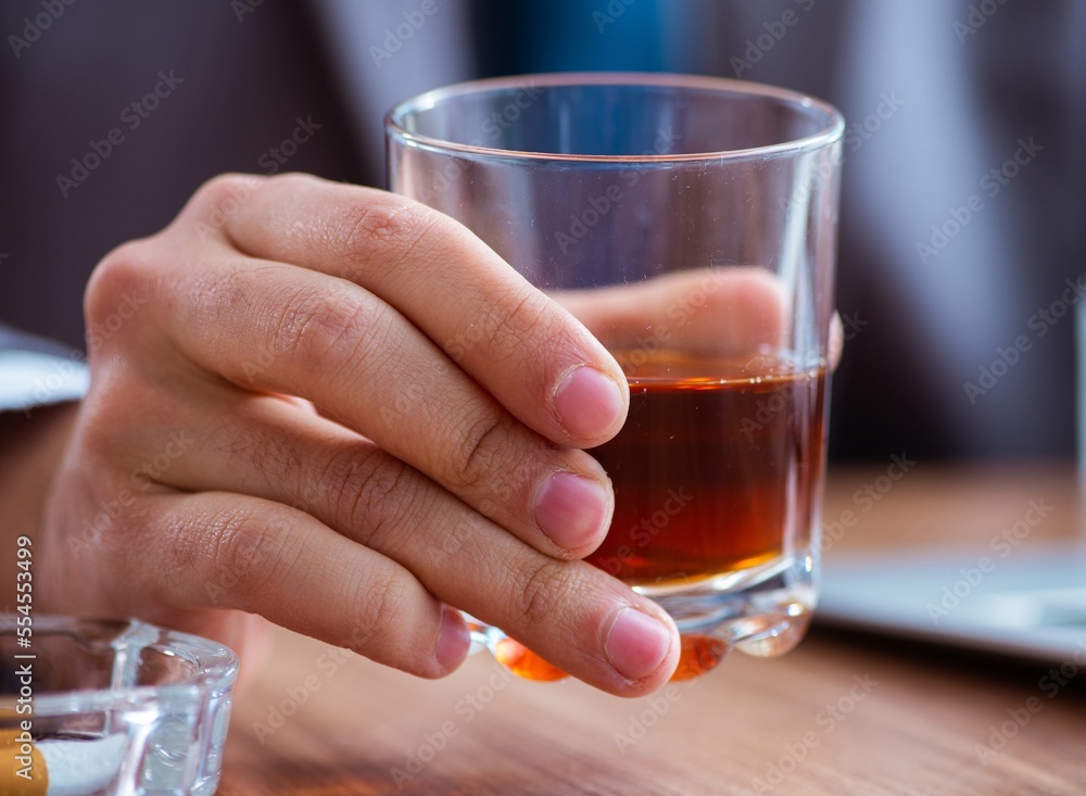 Male employee drinking alcohol and smoking cigarettes at workpla Male employee drinking alcohol and smoking cigarettes at workpla