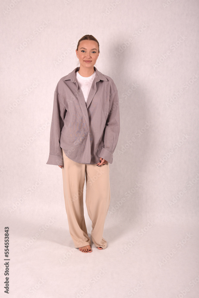 © Шамиль Алиев - A young girl in beige home clothes on a white background in the studio