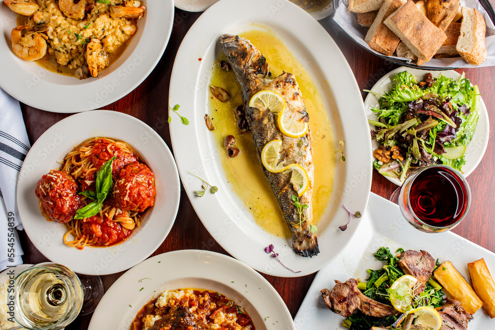 Grilled Fish. Italian Dinner table. Pasta, grilled sea bream. Classic regional Greek seafood favorite. Whole fish, grilled with skin in, served with lemon potatoes lemons Italian parsley and capers. Grilled Fish. Italian Dinner table. Pasta, grilled sea bream. Classic regional Greek seafood favorite. Whole fish, grilled with skin in, served with lemon potatoes lemons Italian parsley and capers.