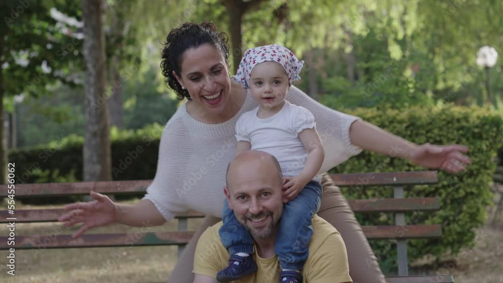 Happy young family at the park in spring with their little girl Happy young family at the park in spring with their little girl