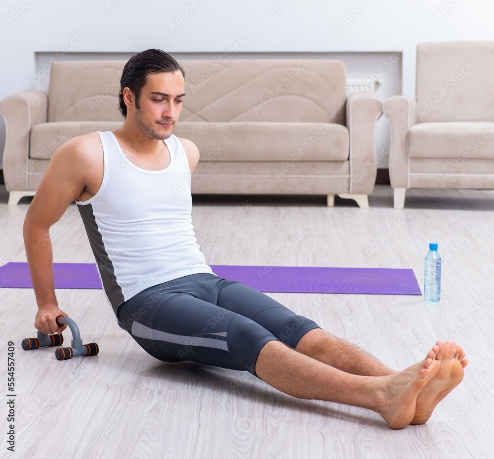Fototapeta premium Young man training and exercising at home