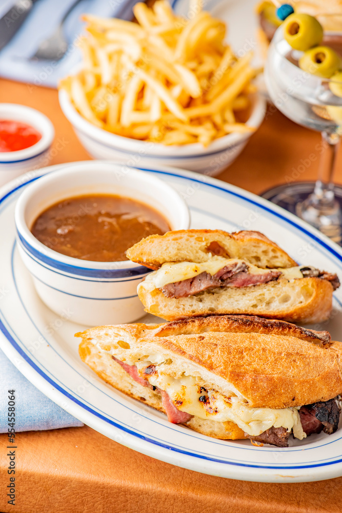 Reuben Sandwich. Classic traditional American sandwich. Pastrami and corned beef on grilled rye bread, melted Swiss cheese, sauerkraut, topped with thousand island dressing served french fries.