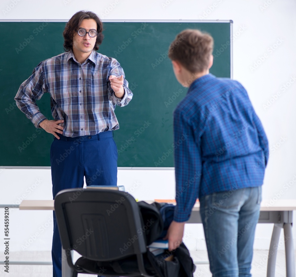 Fototapeta premium Funny male teacher and boy in the classroom