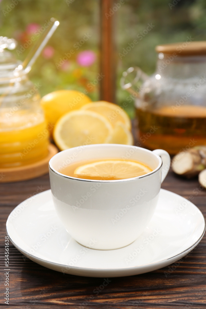 Cup of delicious tea with lemon and honey on wooden table Cup of delicious tea with lemon and honey on wooden table