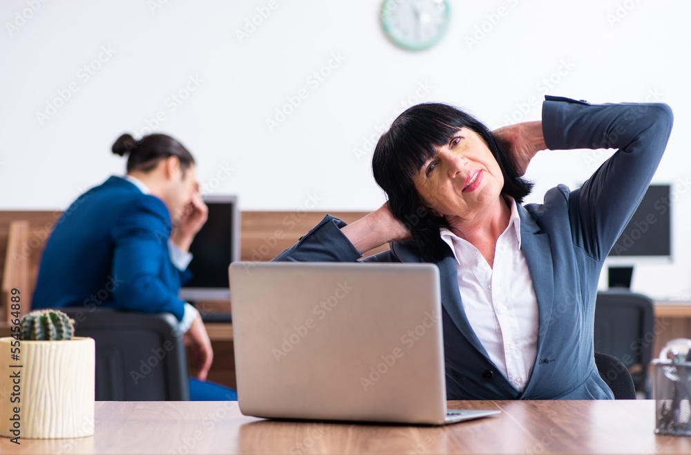 Two employees doing sport exercises in the office Two employees doing sport exercises in the office