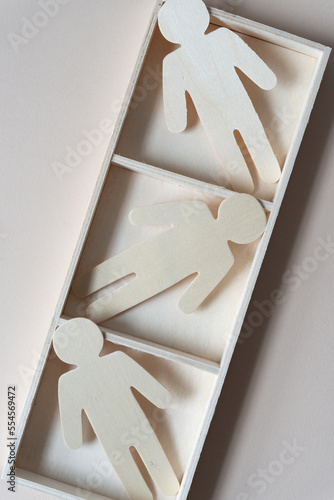 Fotografie three wooden stick figures in a 3 part box