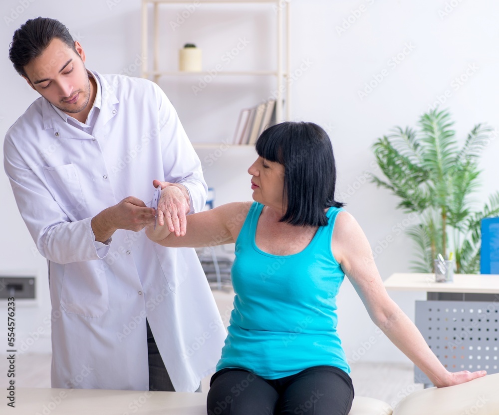 Obraz premium Young male doctor examining old female patient