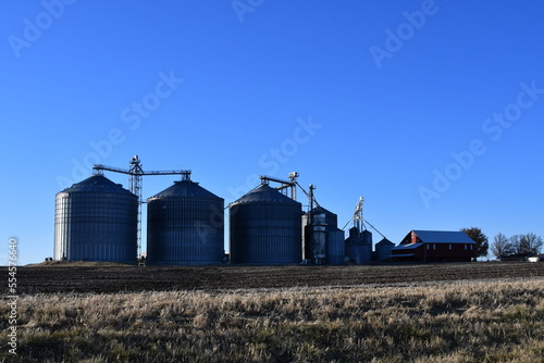 Grain Bins and a Barn in a Farm Field
